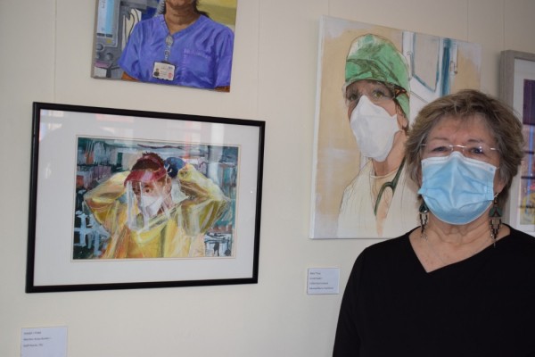 Podi Lawrence with portrait of Dr Ian Mew: Anaesthetics Consultant + Critical Care Medic